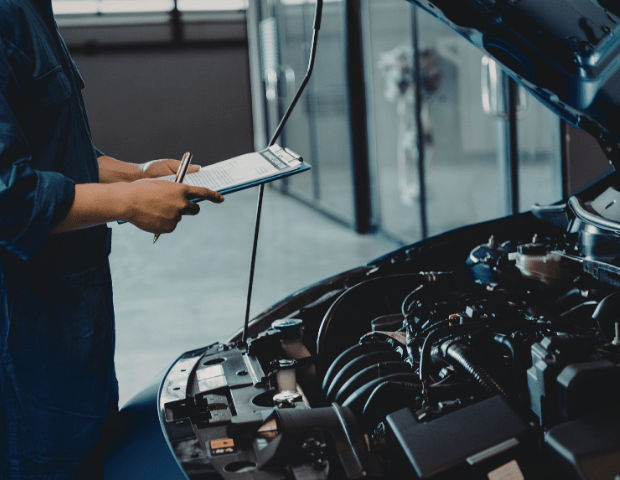 An appraiser checking a vehicle condition at a Fort Walton Beach car lot